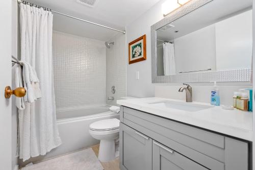 uma casa de banho branca com um lavatório e um WC em Hale Kekai on Bishop 2412 - 30-Day Minimum em Honolulu