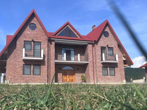a large brick house with a red roof at Begaso Family Winery in Kvareli