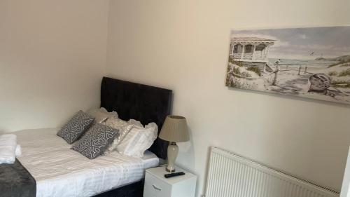 a bedroom with a bed and a painting on the wall at POTTERS LODGE by Edl Ventures Ltd in Manchester