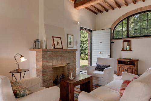 a living room with white furniture and a fireplace at Podere Ferranino at Ville Ferrano in San Giovanni dʼAsso