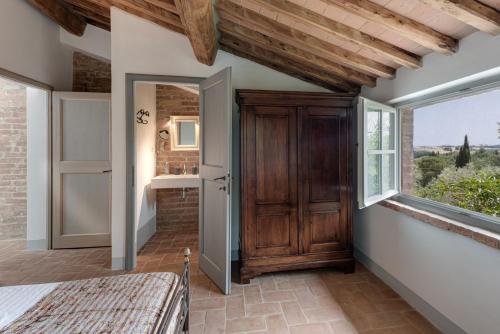 a bedroom with a wooden door and a window at Podere Ferranino at Ville Ferrano in San Giovanni dʼAsso