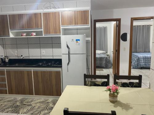 a kitchen with a table and a refrigerator at Aptos Weber - Piratini in Gramado