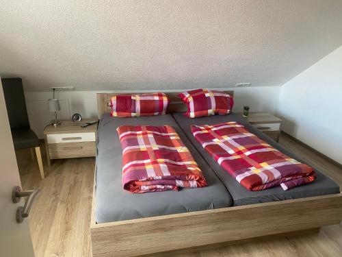 a bed with two pillows on it in a room at Hohennneuffen Blick in Beuren