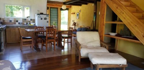 cocina y comedor con mesa y sillas en Casa cerca del lago en Lago Puelo