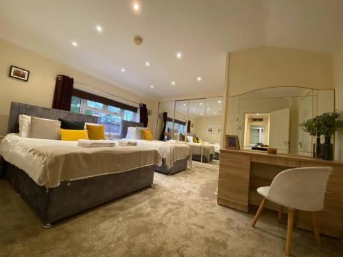 a large bedroom with two beds and a mirror at Fabulous Spacious Bungalow in Solihull close to Bham Airport NEC & Bham City Centre in Knowle