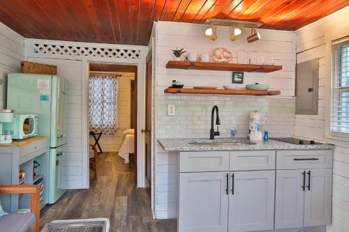 - une cuisine avec des placards blancs et un évier dans l'établissement 1 - Seahorse Cottages, à St. Pete Beach