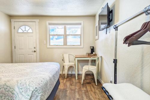 1 dormitorio con 1 cama, mesa y sillas en The Fountain Creek Inn of Manitou Springs, en Manitou Springs