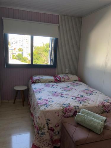 um pequeno quarto com uma cama e uma janela em CASA NO BORGO MOBILIADA em Bento Gonçalves