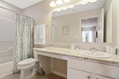 a bathroom with a sink and a toilet and a mirror at Family Friendly Four Bedrooms 5145 in Kissimmee