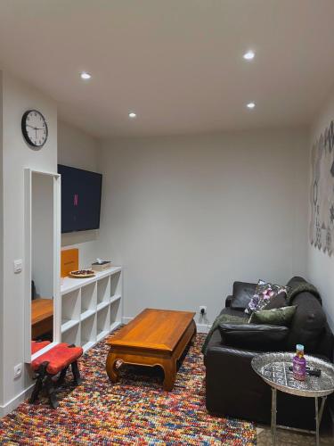 una sala de estar con un sofá y una mesa en Apparte/Hotel de Luxe, en Melun