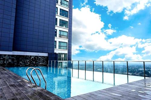 ein Schwimmbad vor einem hohen Gebäude in der Unterkunft Apartment Embarcadero Bintaro Suites by Novie Mckenzie in Pondokaren