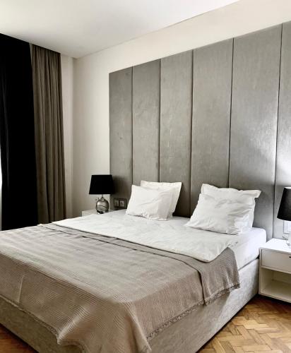 - une chambre dotée d'un grand lit avec des draps et des oreillers blancs dans l'établissement City centre HOTEL STYLE APARTMENT, à Baku