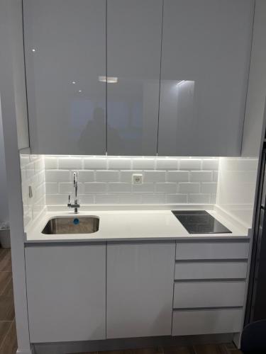 a kitchen with white cabinets and a sink at BERNABEU/ C.UNIVERSITARIA APARTMENTS in Madrid