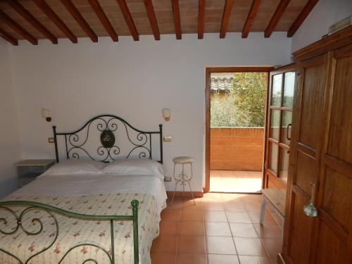 a bedroom with a bed and a sliding glass door at Fullino Nero Rta - Residenza Turistico Alberghiera in Siena