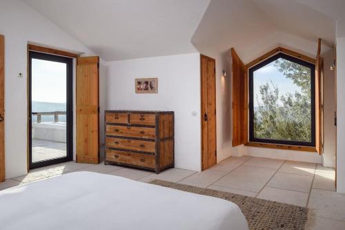 a bedroom with a bed and a large window at Monte “SERRA E MAR” in Melides