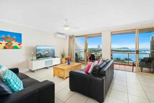 uma sala de estar com um sofá e uma televisão em Little Cove Currumbin em Gold Coast