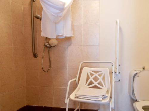 a shower with a white chair in a bathroom at Lower Hameldown-uk12424 in Widecombe in the Moor