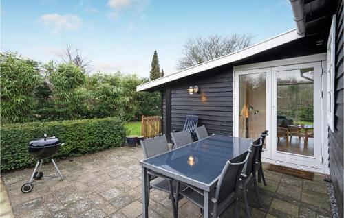 un patio avec une table, des chaises et un barbecue dans l'établissement 3 Bedroom Lovely Home In Gørlev, à Gørlev