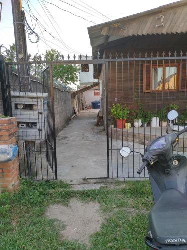 a scooter parked next to a gate in front of a house at Kitnet SIMIROMBA in Pelotas