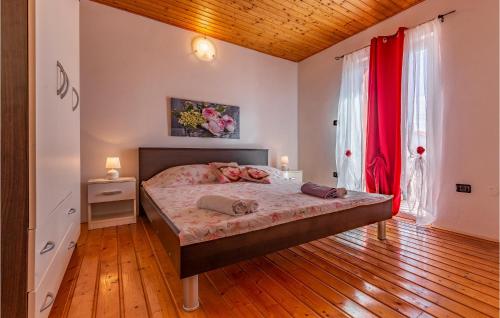 een slaapkamer met een groot bed met rode gordijnen bij Beautiful Home In Sisan With Outdoor Swimming Pool in Šišan