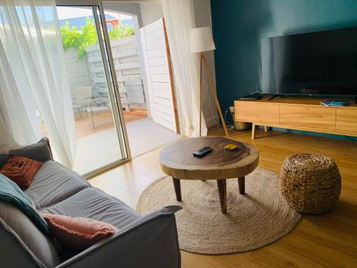 ein Wohnzimmer mit einem Sofa und einem Couchtisch in der Unterkunft Colors by MG2 in Saint Martin