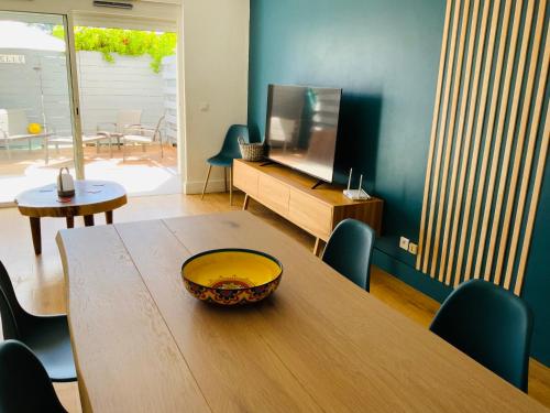 a living room with a wooden table and a television at Colors by MG2 in Saint Martin