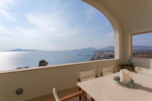a dining room with a table and a view of the water at Villa Itis Superb Residence with Balcony & Panoramic View in Neapolis