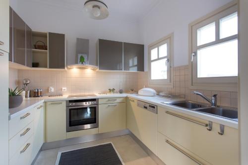 a kitchen with white cabinets and a sink at Villa Itis Superb Residence with Balcony & Panoramic View in Neapolis