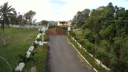 a road leading to a house with a fence at Lavender Moon Villas in Breadnut Hill