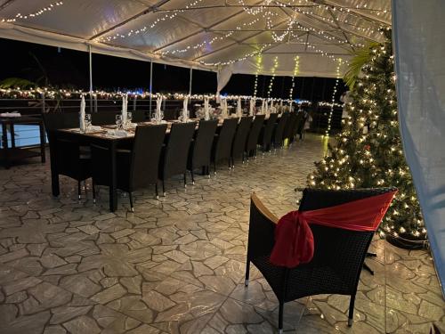 a dining room with a christmas tree and tables and chairs at Lavender Moon Villas in Breadnut Hill