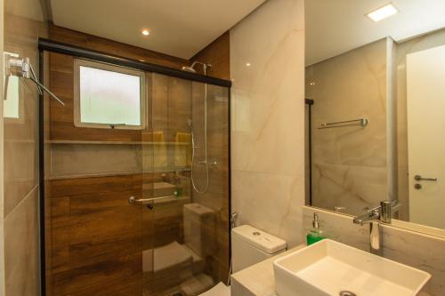 a bathroom with a glass shower and a sink at Edif Flat Beira Mar in Recife