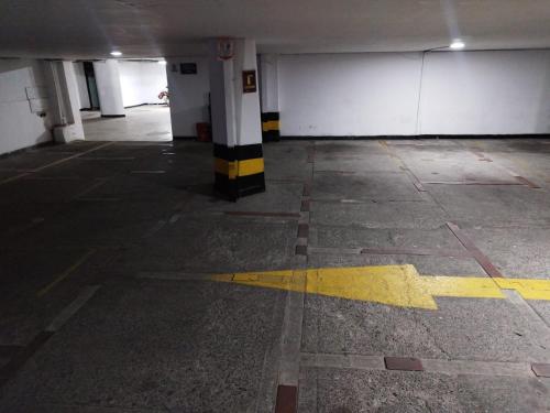 an empty parking garage with a yellow line on the floor at Hotel Residencias Noches De París in Cali