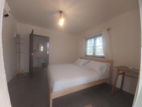1 dormitorio con cama blanca y ventana en Nice Home Stay @Samroiyot, en Sam Roi Yot