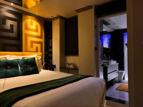 een slaapkamer met een groot bed met groene kussens bij Exclusive Apartments South Kensington in Londen