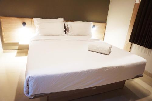 a large white bed with a white pillow on it at Kanna Stay in Semolowaru
