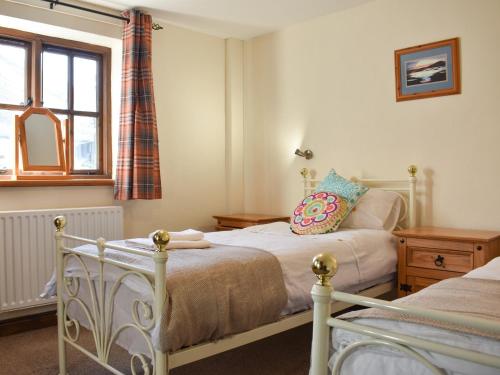 a bedroom with two beds and a window at Combe Cottage-uk42228 in Low Borrowbridge