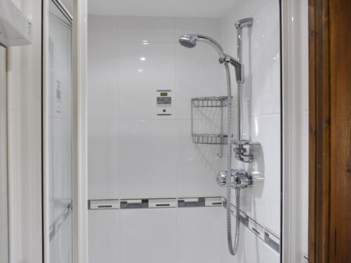 y baño con ducha con cabezal de ducha. en Combe Cottage-uk42228, en Low Borrowbridge