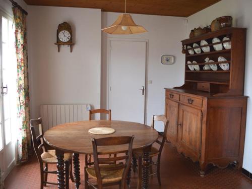 une salle à manger avec une table, des chaises et une horloge dans l'établissement Maison à 220m de la plage Centrale, Jardin clos, Terrasse, Proche commerces, Animaux acceptés - FR-1-22-214, à La Tranche-sur-Mer