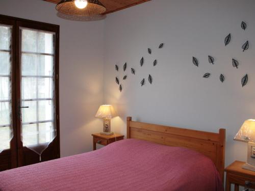 - une chambre dotée d'un lit avec des draps violets et des papillons sur le mur dans l'établissement Maison avec Jardin Proche Plage et Forêt - La Tranche-sur-Mer - FR-1-22-217, à La Tranche-sur-Mer