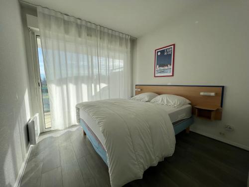 a bedroom with a bed and a large window at Appartement à Ciboure avec piscine chauffée et parking privé - FR-1-239-560 in Ciboure