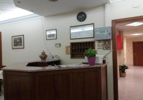 a kitchen with a counter with a sink and a clock at Hotel Ferrari in Rome