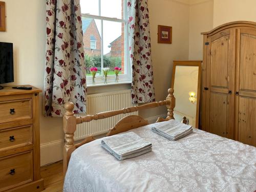 a bedroom with a bed with two towels on it at Station House in Hornsea