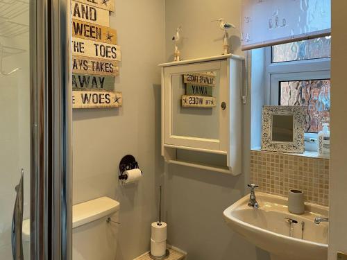 a bathroom with a sink and a toilet and a window at Station House in Hornsea