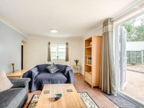 a living room with a couch and a table at Managers Cottage in Loddon