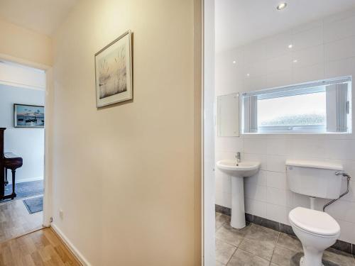 a white bathroom with a toilet and a window at Heritage Wharf in Mow Cop