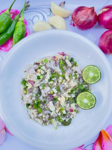 a white plate of food with rice and lime slices at bucu hidden guest house, and meditation center in Payangan