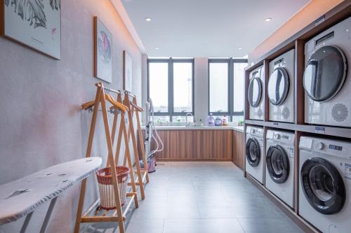 a laundry room with washing machines and a window at Rezen Longuu Hotel - Universiade Center Longgang Shenzhen in Longgang