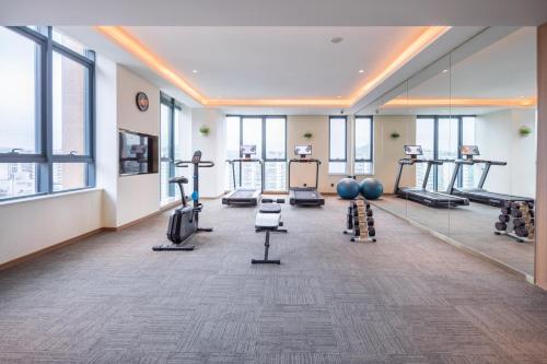 a gym with treadmills and exercise equipment in a building at Rezen Longuu Hotel - Universiade Center Longgang Shenzhen in Longgang