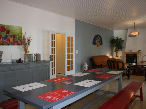 une salle à manger avec une table et des tapis rouges dans l'établissement Villa spacieuse avec terrasse en bord de mer et animaux acceptés - FR-1-22-249, à La Tranche-sur-Mer