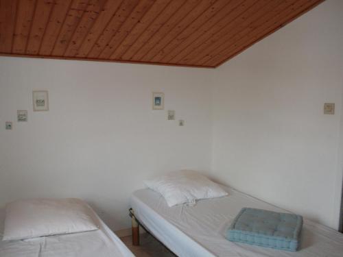 une chambre avec deux lits et un plafond en bois dans l'établissement Maison cosy à 900m de la plage avec jardin clos et parking privatif - FR-1-22-182, à La Tranche-sur-Mer